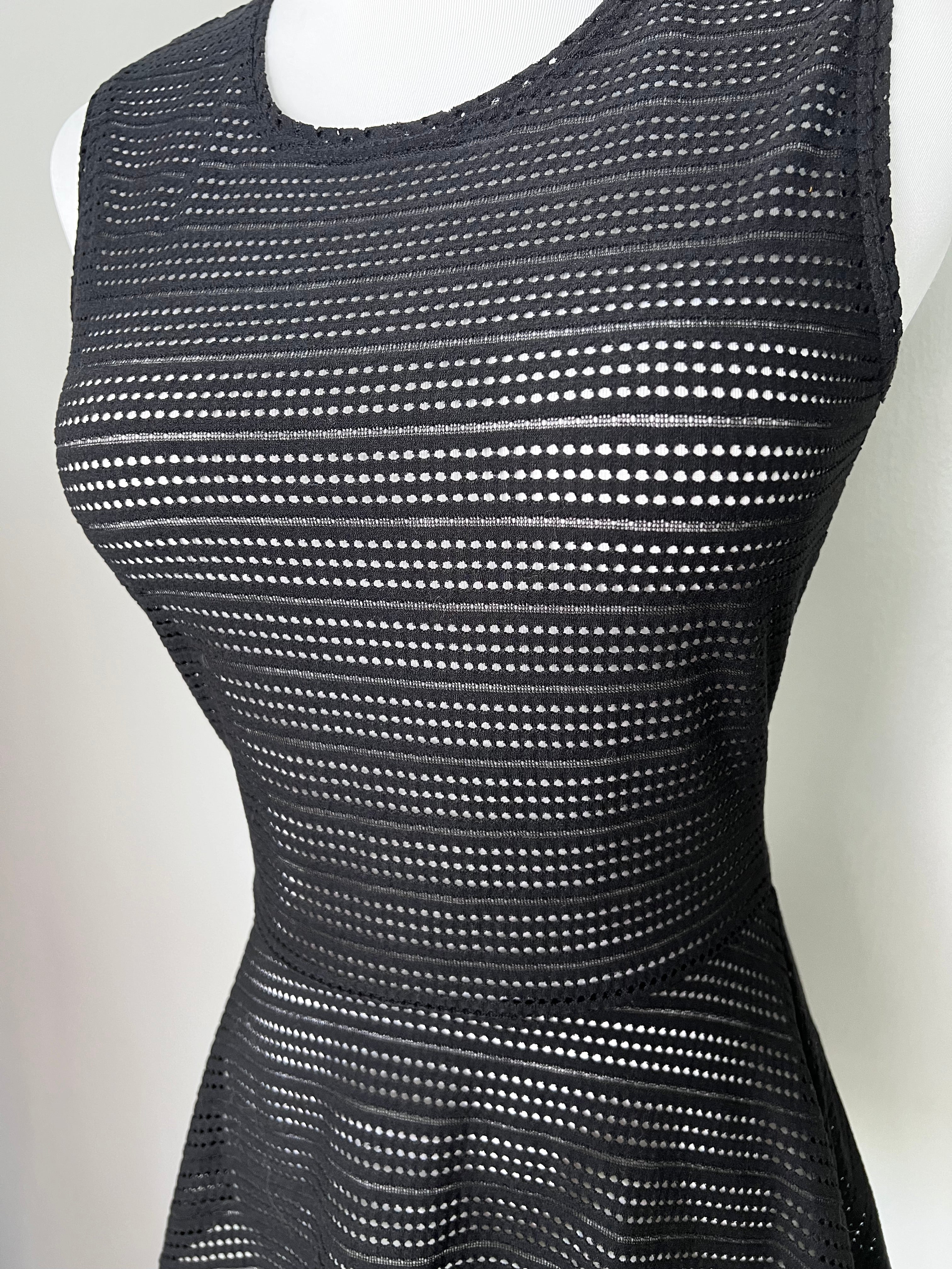 Black sleeveless  top with hole detailing throughout. -BCBGMAXAZRIA
