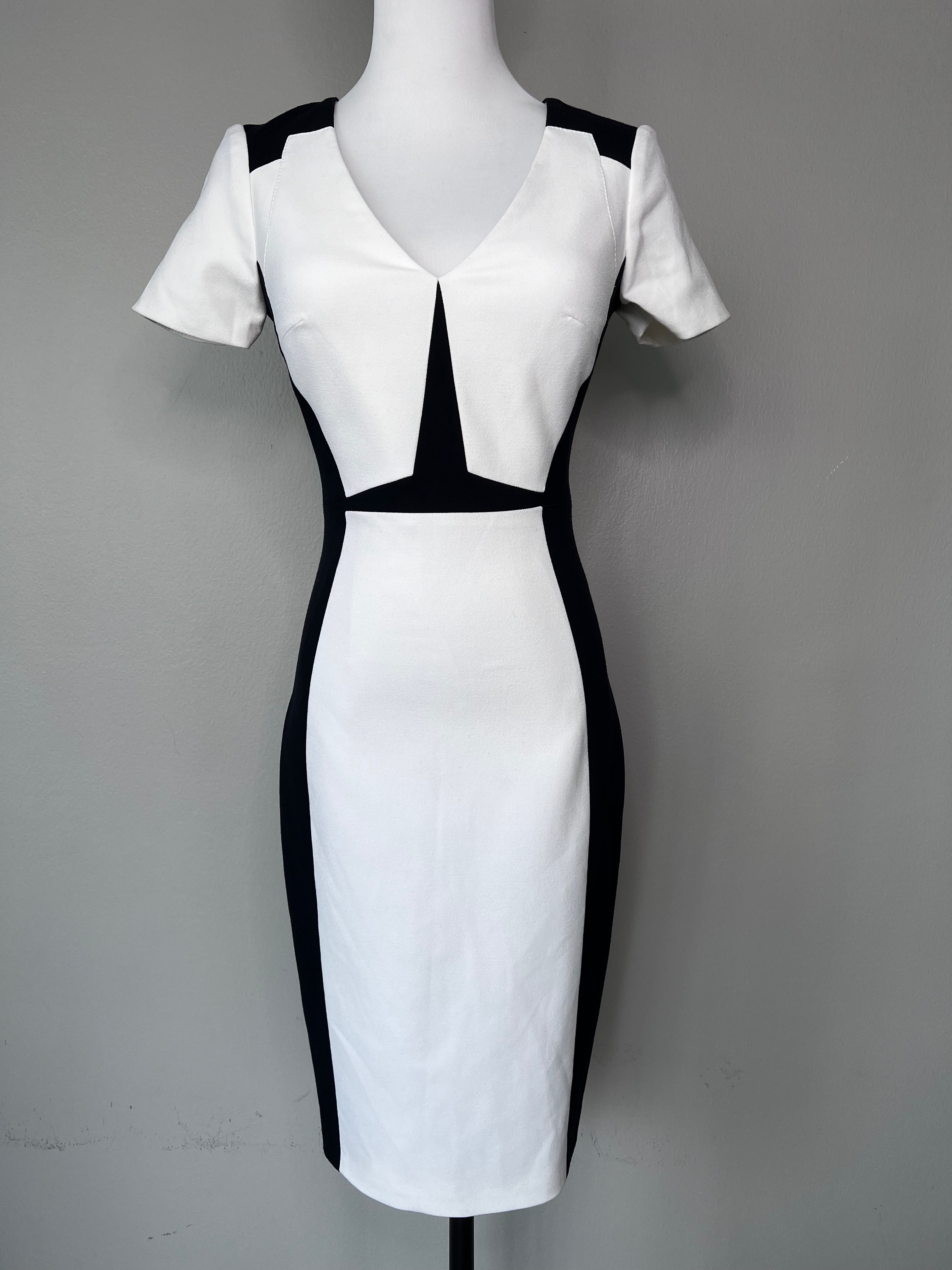 White knee-length dress with a v-neck, and black detailing on the shoulders and at the outer part of the waist. - KAREN MILLEN