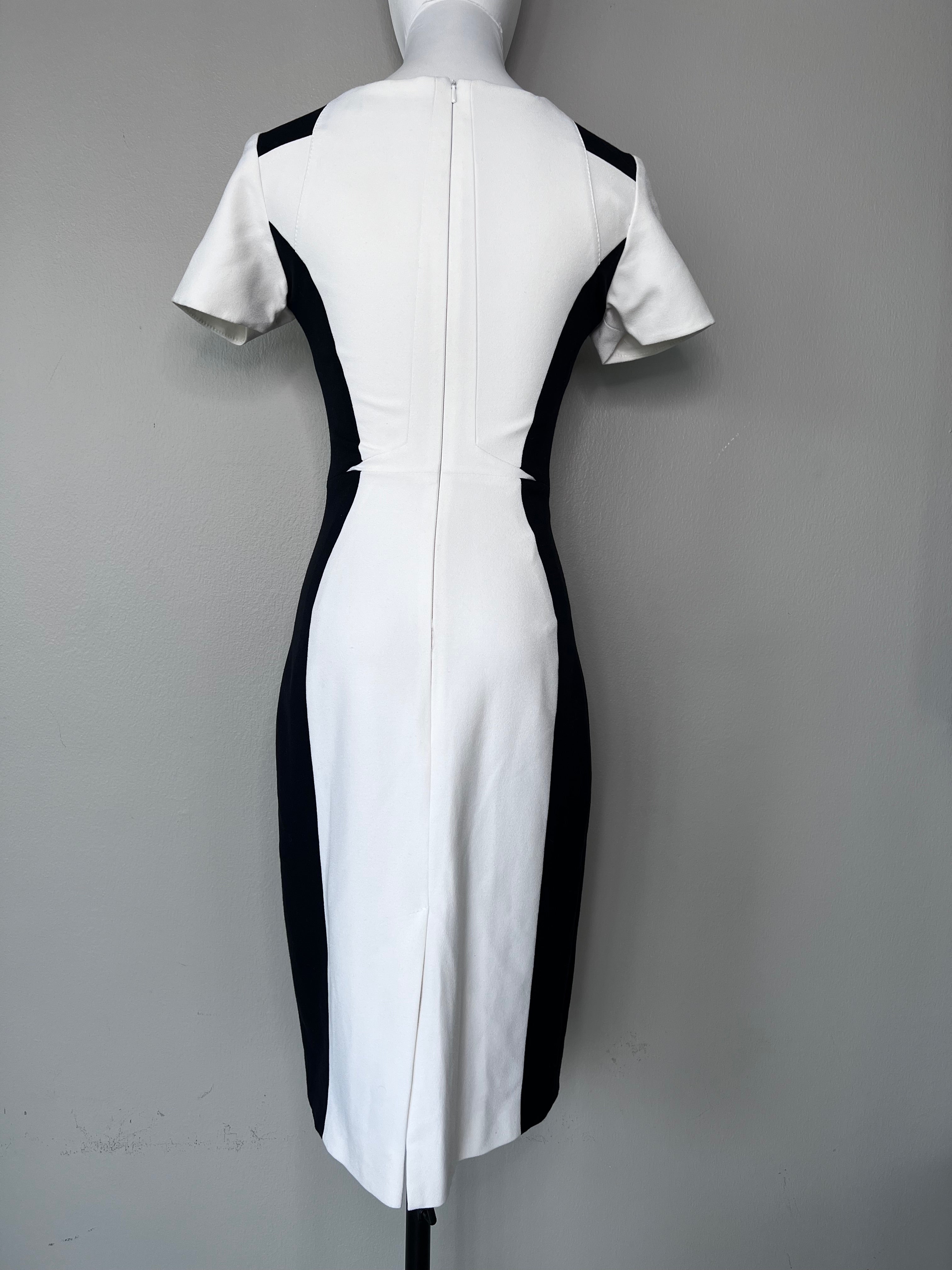 White knee-length dress with a v-neck, and black detailing on the shoulders and at the outer part of the waist. - KAREN MILLEN
