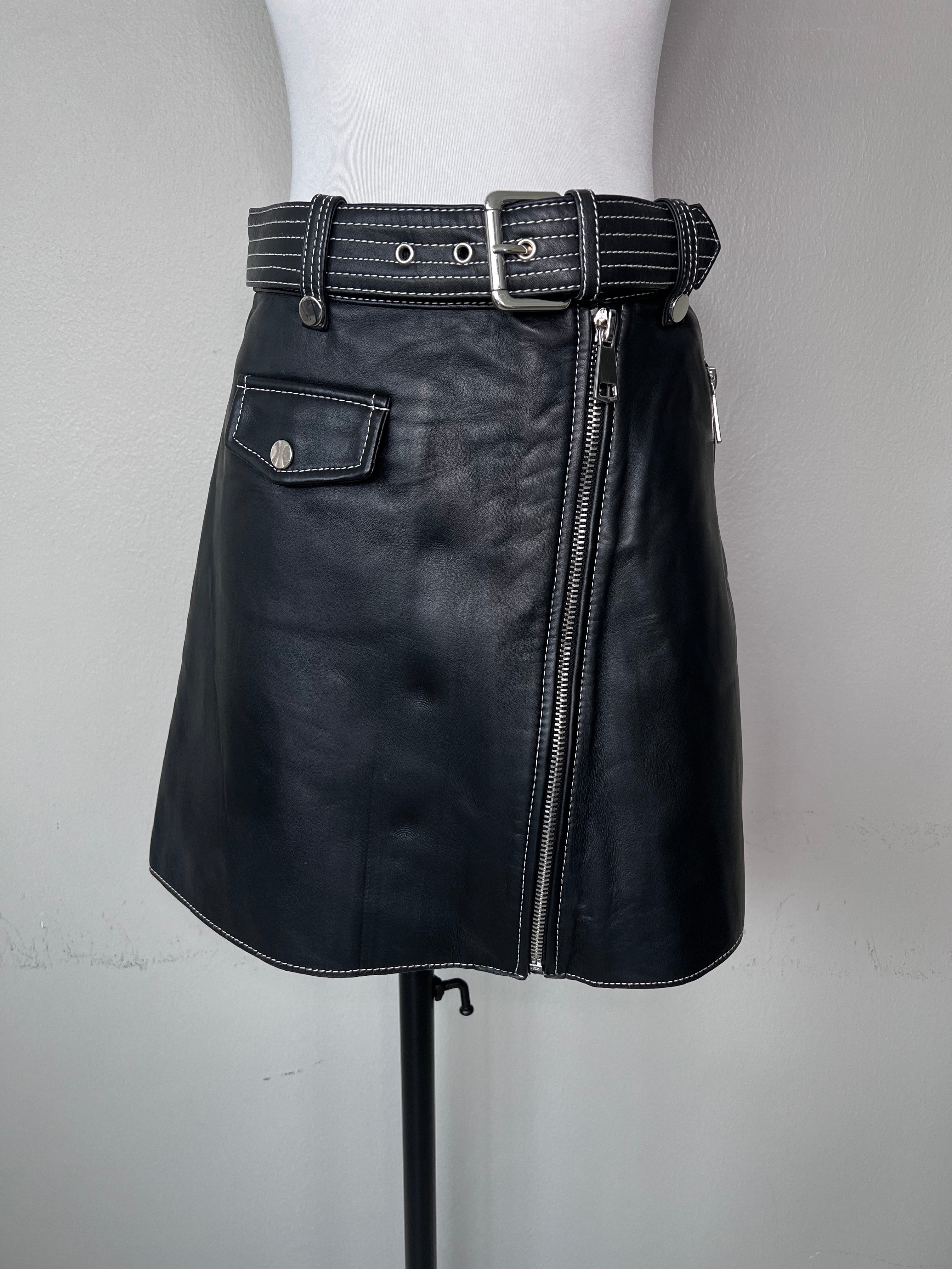 Black a-line short leather skirt with zipper down the middle and matching belt with white stitching detail. - MAJE