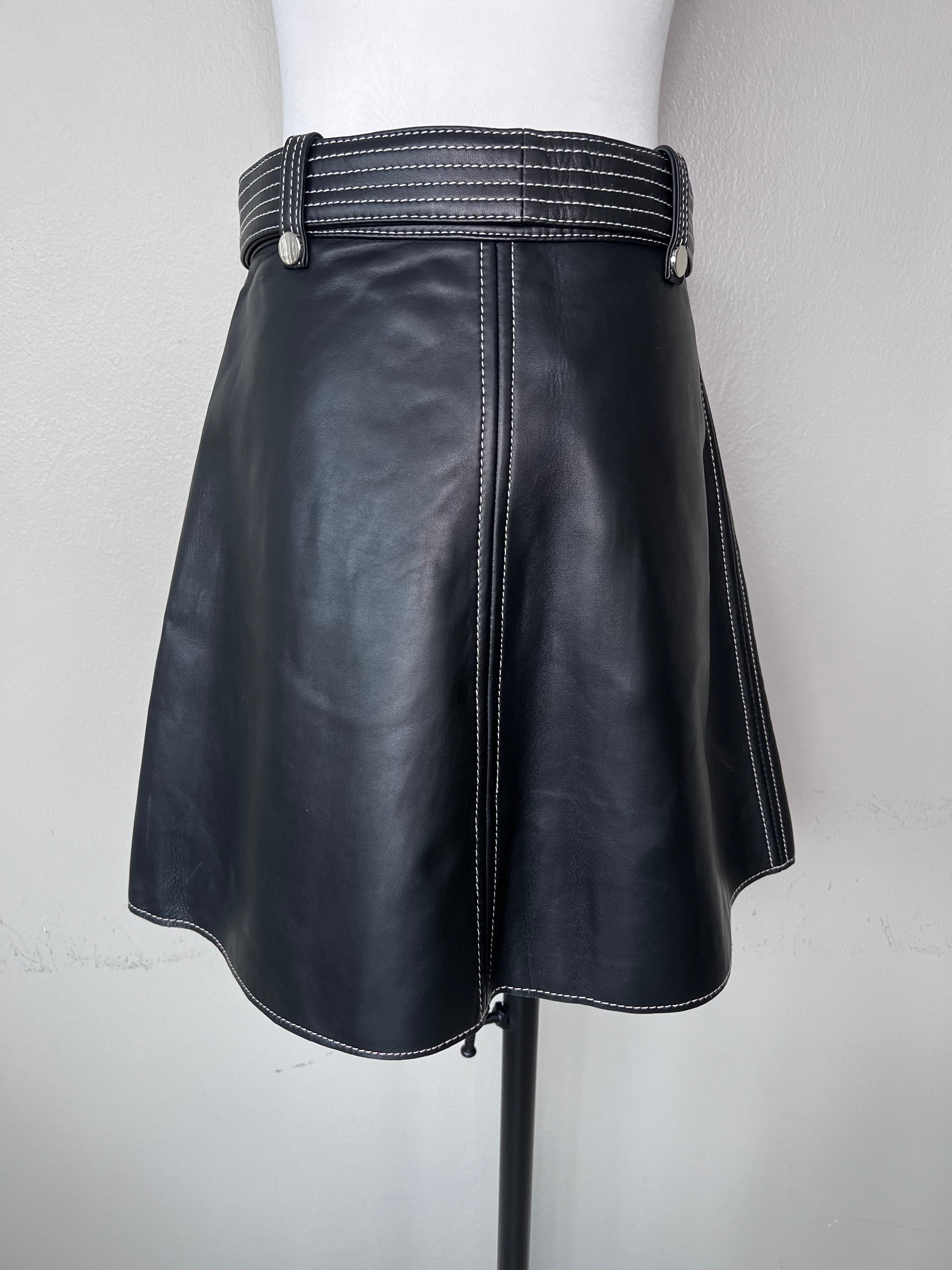 Black a-line short leather skirt with zipper down the middle and matching belt with white stitching detail. - MAJE