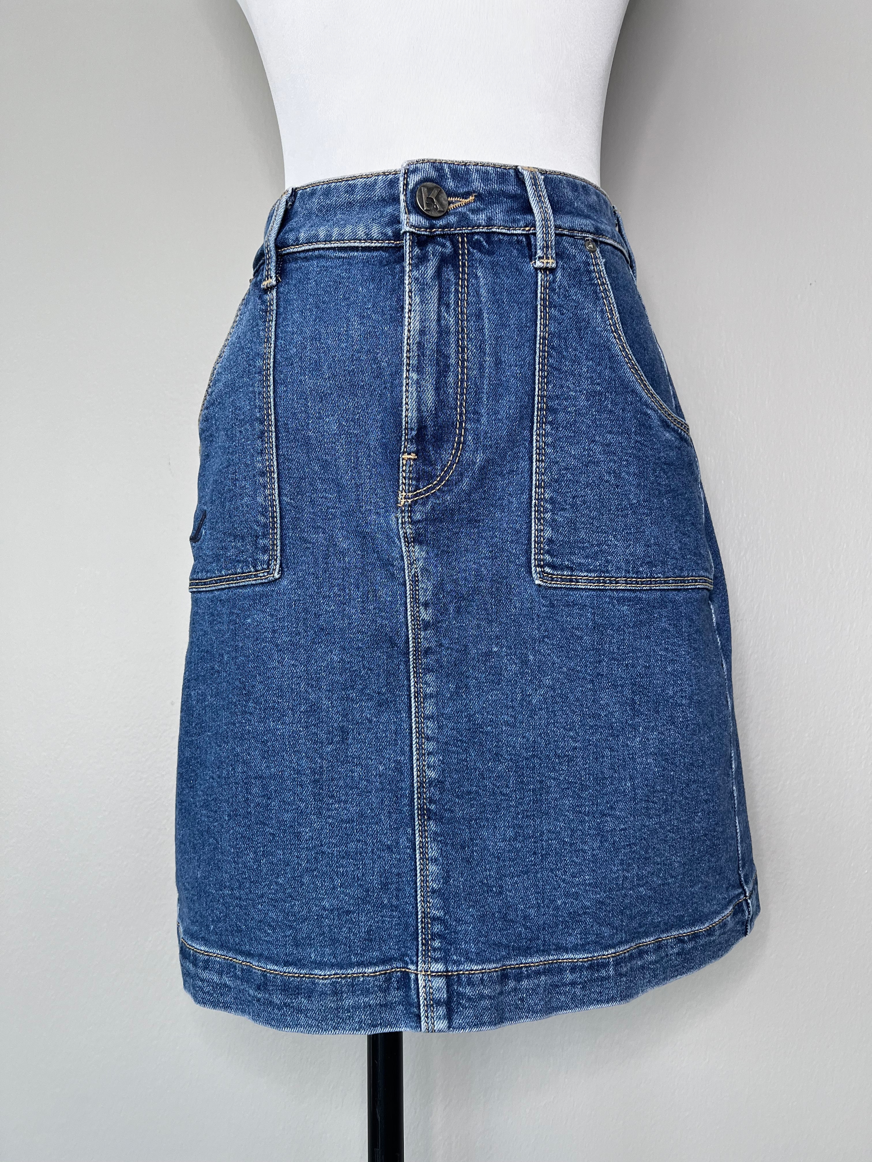 Blue short denim skirt with pockets on either side at the front and back, and brand logo at the back pocket.- KARL LAGERFELD DENIM