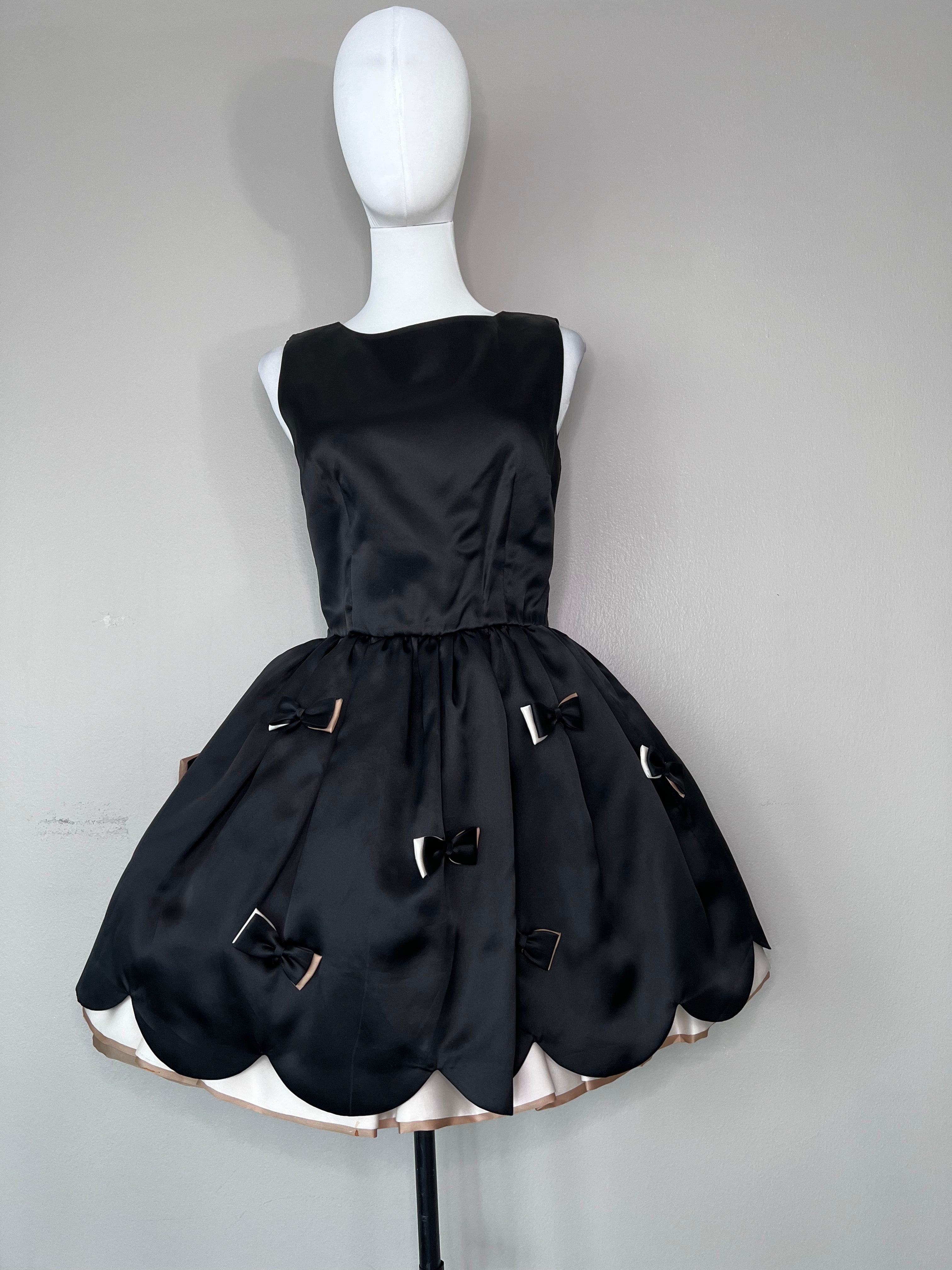 Red Valentino black sleeveless cocktail dress with bows at the skirt and beige lining. -RED VALENTINO
