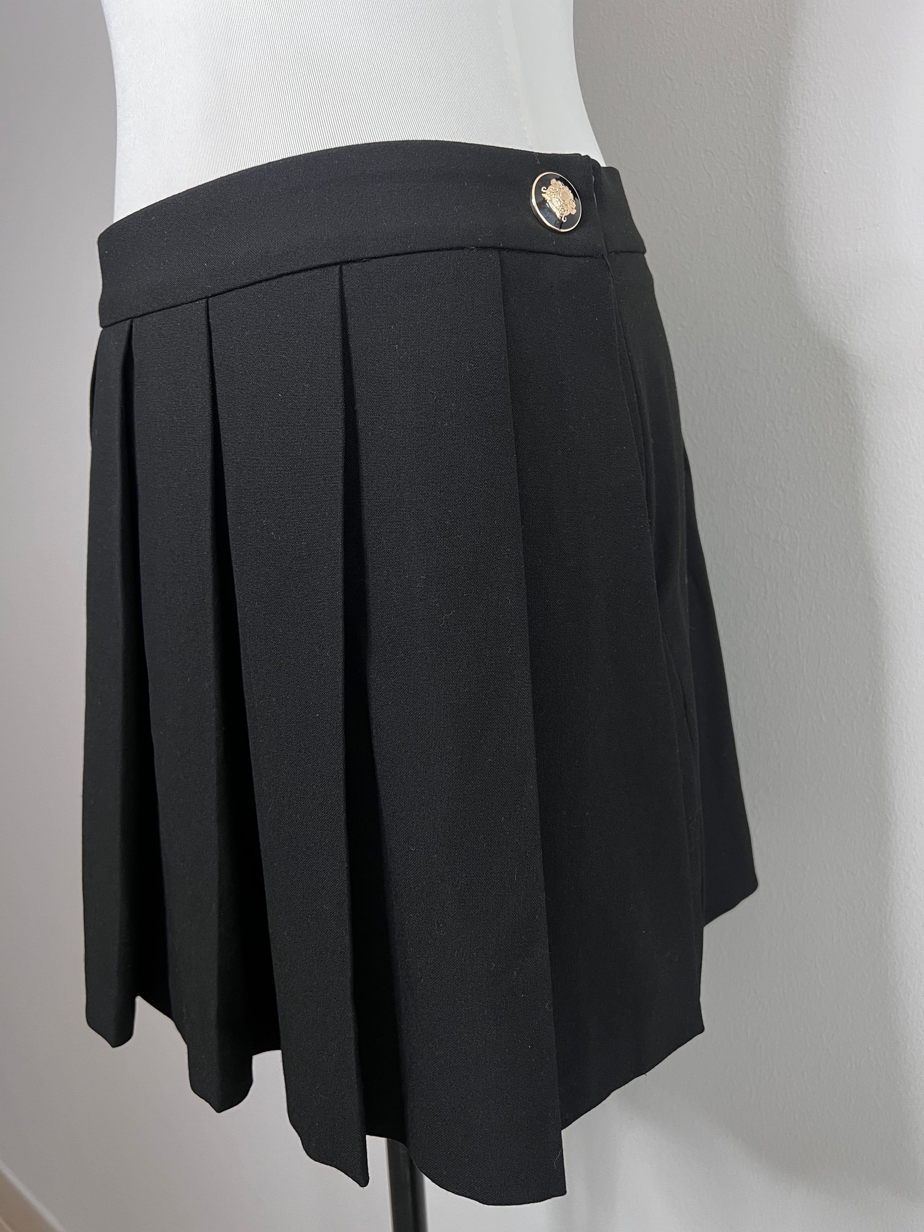 Pleated mini black skirt with gold button on the right - ZARA